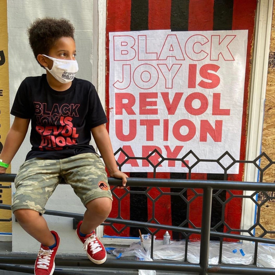 Boy sitting in front of Black Joy Is Revolutionary Art